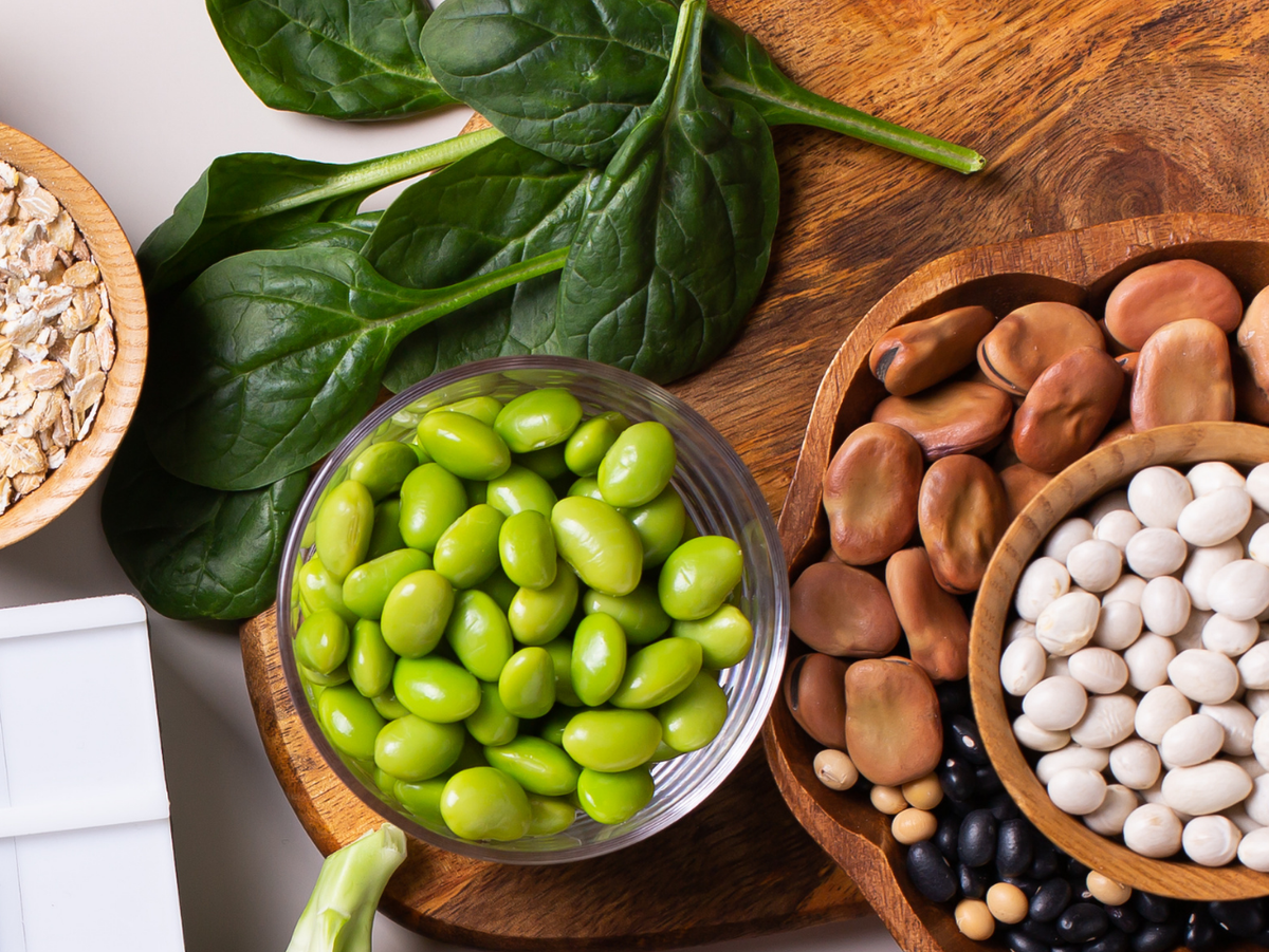 Realistic high-protein foods including beans, spinach, and edamame